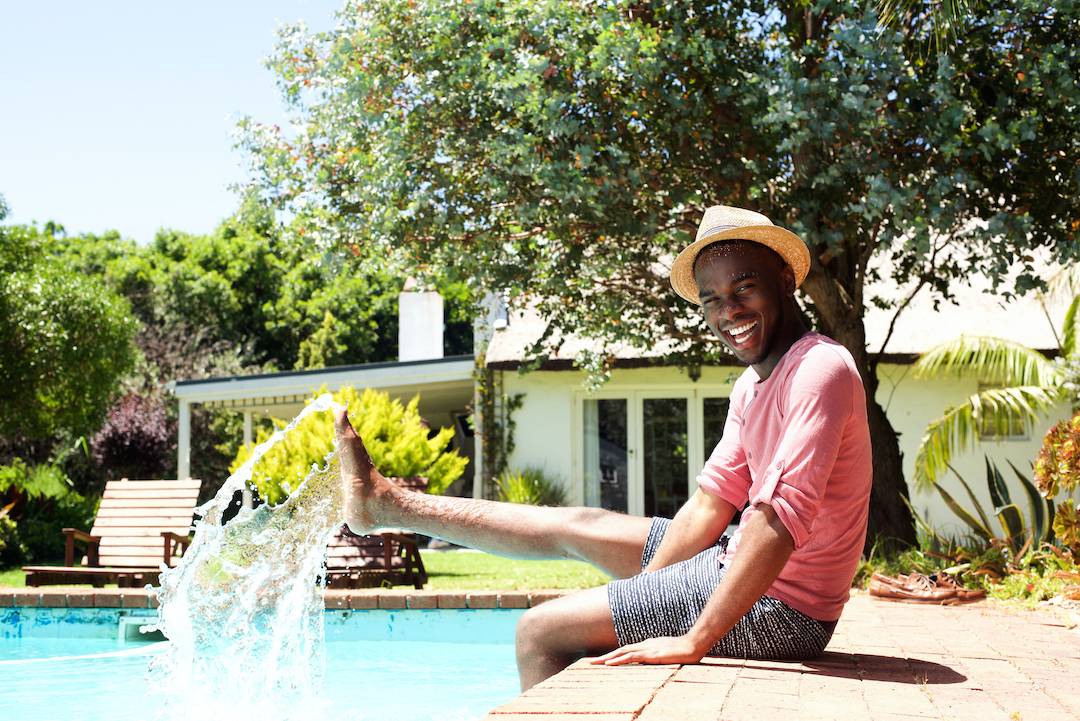 man sitting by the pool thinking about contact lenses for swimming