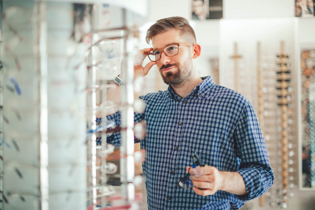 man trying on different glasses types