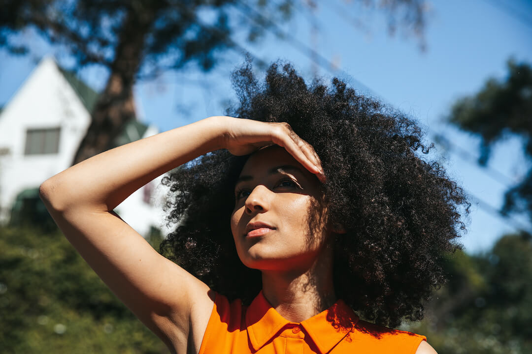 woman in need of contact lenses for light sensitivity blocking her eyes