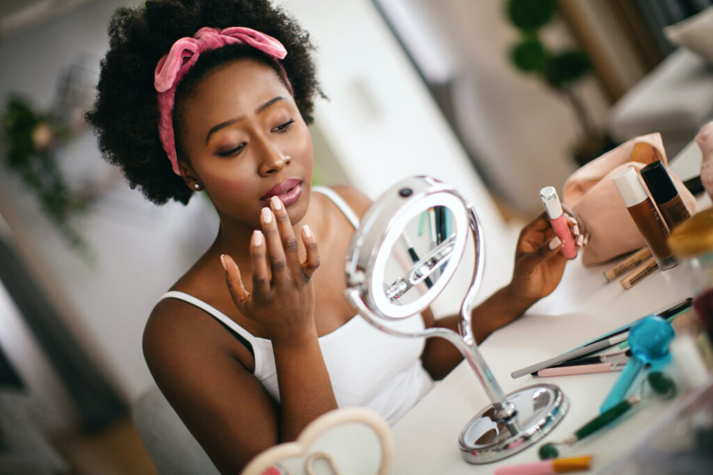 young woman putting on makeup