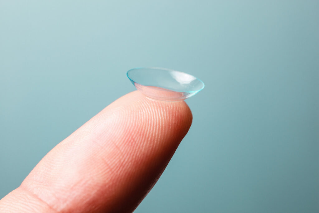 holding a single contact lens on the tip of a finger