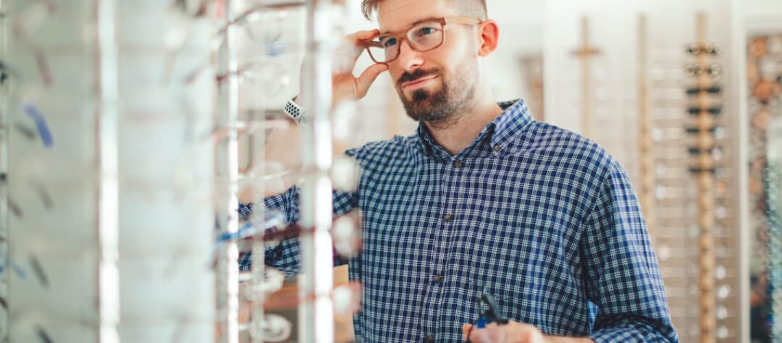 man trying on different glasses types